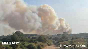 Vehicle fire spreads to heathland as crews fight blaze