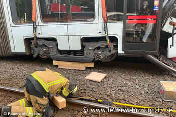 Feuerwehrkran hebt deformierte Straßenbahnen auf Rollwagen