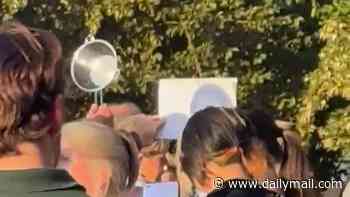 Moment man uses colander at packed London park to watch the eclipse... and he's not alone