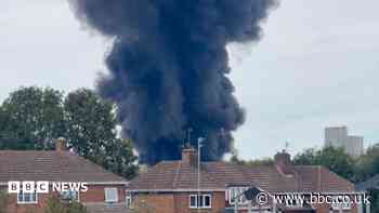 Black smoke billows over town from industrial fire
