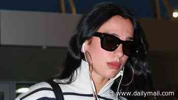 Dua Lipa nails riviera chic in stripes and jeans while making a statement with a VAST Chanel bucket bag as she jets out of JFK Airport