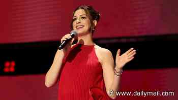 Pregnant Anne Hathaway, 43, covers baby bump in quirky red look at Disney event... after being roasted over maternity style