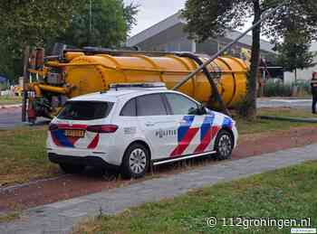 Trailer met mest kantelt op rotonde Winsum