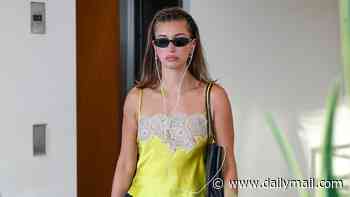 Hailey Bieber goes braless in a satin green cami top as she heads to celebrity sushi hotspot in Los Angeles