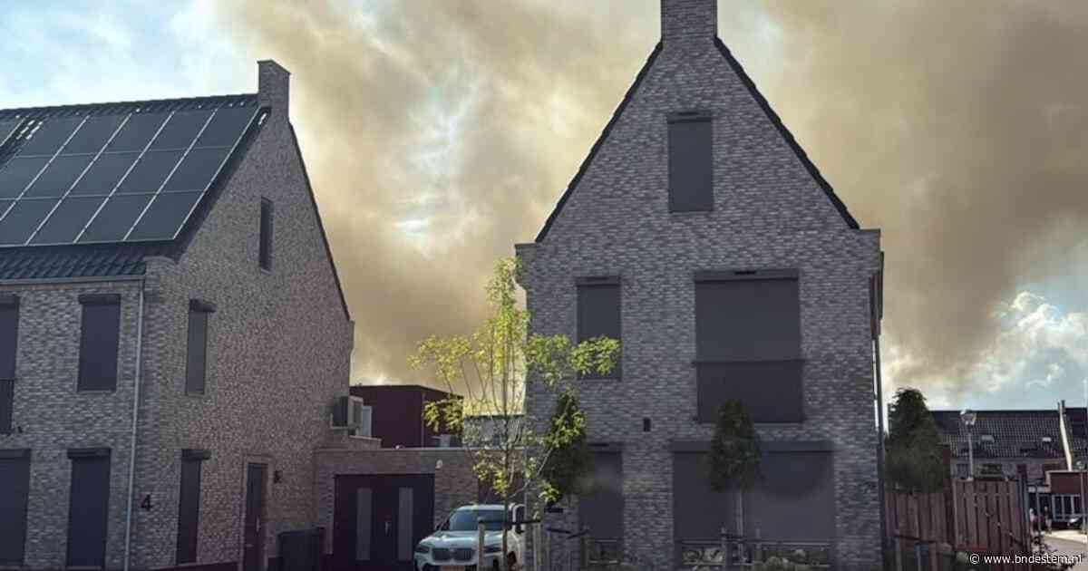 Uitslaande brand in stal in Zevenbergen, rook trekt over dorp heen