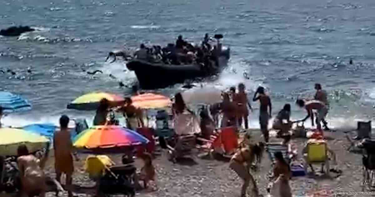 Verbazing bij strandgangers in Spanje: migranten springen voor kust uit overvolle boot en zwemmen naar strand