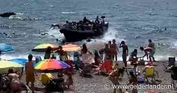 Verbazing bij strandgangers in Spanje: migranten springen voor kust uit overvolle boot en zwemmen naar strand