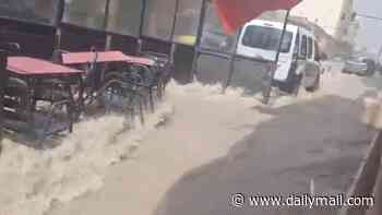Moment freak thunderstorm batters Spain - seeing tourists run for cover as streets turn to rivers