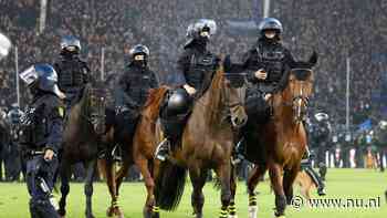 Politie met paarden op het veld bij rellen tijdens Duitse bekerwedstrijd