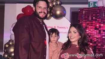 Scarlett Moffatt shows off her baby bump in a heart print dress as she kisses fiancé Scott Dobinson ahead of welcoming their second child