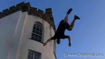Moment reckless daredevils defy police to 'tombstone' into sea from charity's roof
