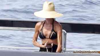Victoria Beckham shows off her toned figure in a black bikini as she relaxes with shirtless husband David on their yacht near Capri amid summer break
