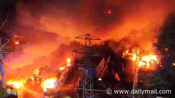 Huge inferno damages 140 cars at holiday parking site near Gatwick Airport as eight fire engines battled blaze: Man, 67, arrested on suspicion of arson