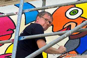 Er macht Auerbach bunter: Star-Künstler bemalt graues Kaufhaus im Vogtland mit Comic-Muppets