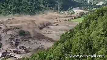 An entire settlement destroyed in just seconds: Video shows huge torrent of floodwater bulldoze through buildings in Nepal as people try to outrun certain death