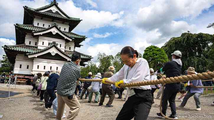 Hundreds of volunteers pull 360-tonne historic Japanese castle back into place by hand
