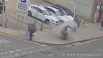 Moment pavement explodes just feet from shoppers... before flames start leaping from hole