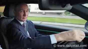 Vladimir Putin shows off his driving skills as he gets behind the wheel to test new Russian motor