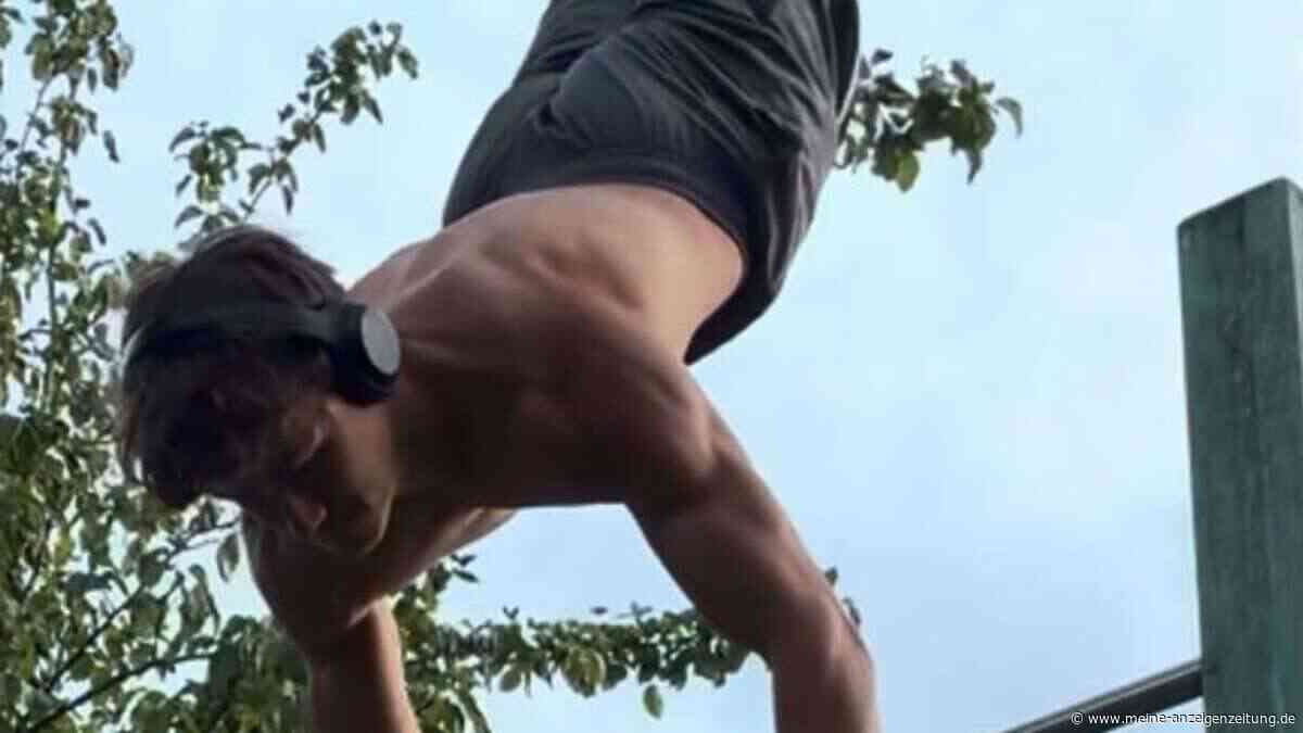 Calisthenics-Athlet zieht sich mit zwei Fingern in den Handstand