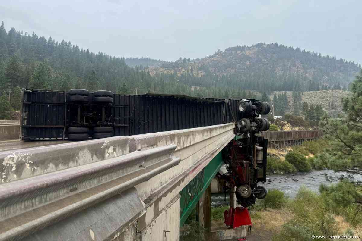 Big rig left dangling over California bridge after crash leaves driver injured