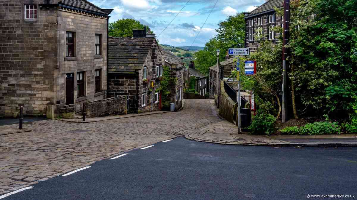 Ancient Yorkshire village with cobbled streets, stone cottages and very famous grave