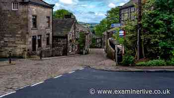Ancient Yorkshire village with cobbled streets, stone cottages and very famous grave