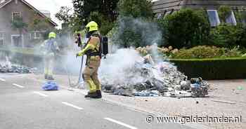Vuilniswagen dumpt brandende lading afval op straat in Herwen, weg dicht