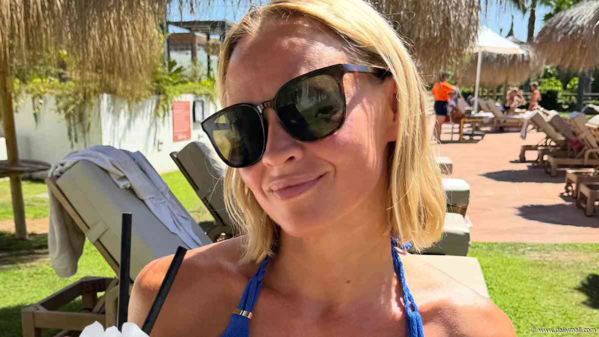 Kimberley Walsh shows off her toned figure in a blue bikini as she sips a frozen cocktail in carefree family snaps from holiday to Spain