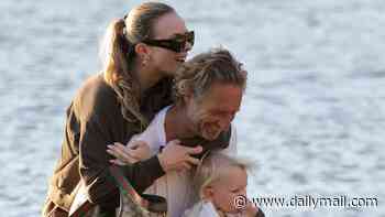 Precious cargo! Justin Hemmes, 54, carries partner Madeline and their one-year-old son Jaeger ashore after arriving home by seaplane
