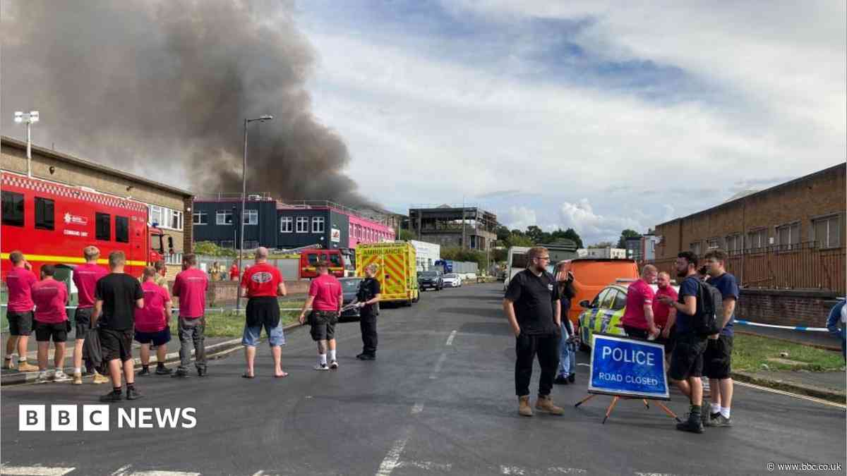 Blasts heard as black smoke rises from fire