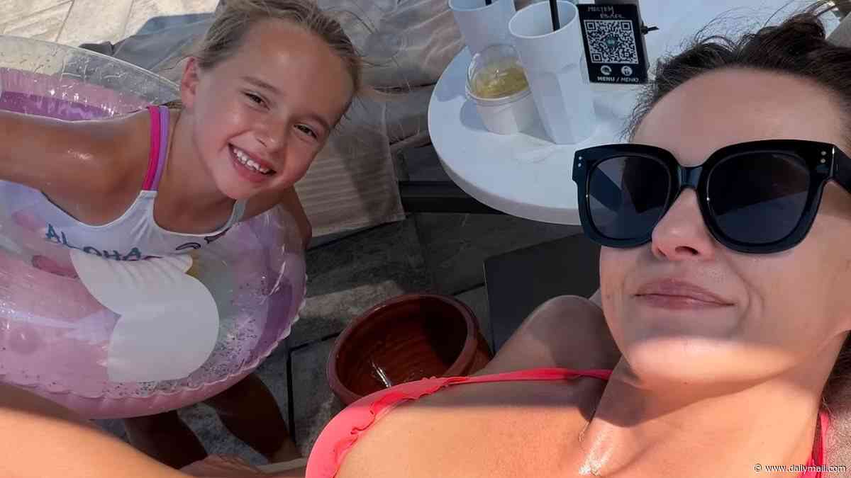 Ola Jordan poses in a hot coral bikini while on holiday with daughter Ella after 'incredibly tough' split from husband James