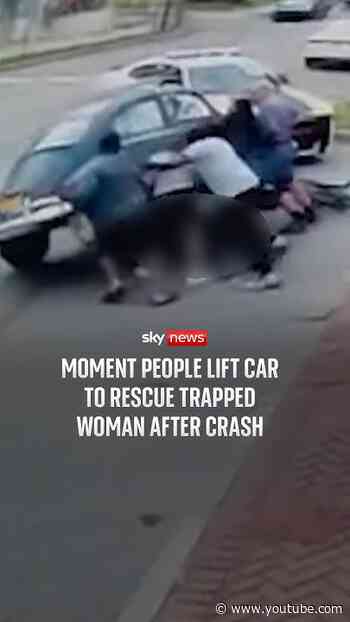 Moment people lift car to rescue trapped woman after crash