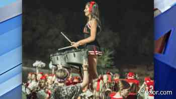 Student cheers and plays in drumline at the same time