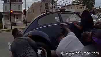 Good Samaritans seen lifting classic Volkswagen Beetle off female e-bike rider after she got trapped under car during collision