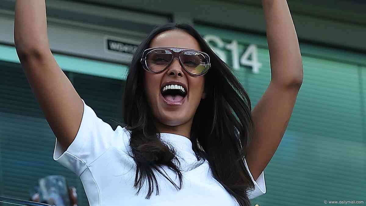 Maya Jama delightedly throws her hands in the air and flashes a glimpse of her midriff as she cheers on the teams at the Women's Super League football match