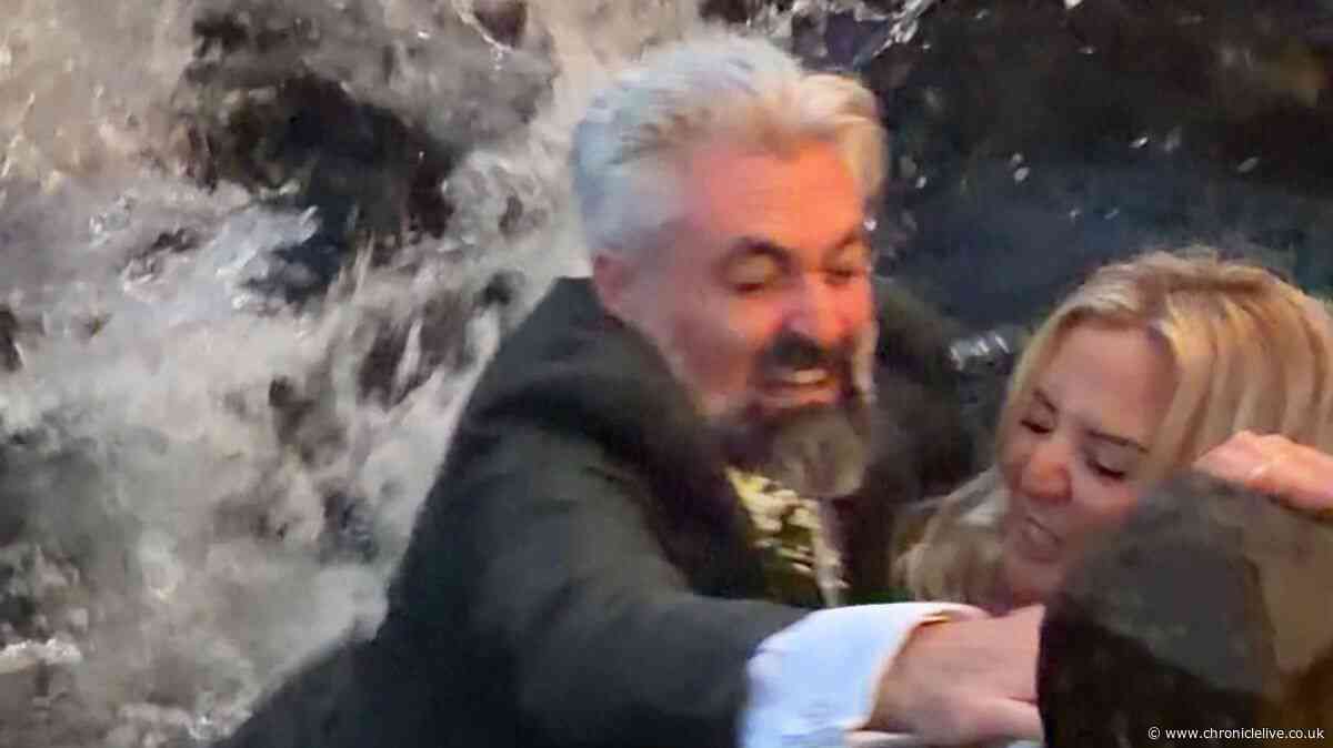Moment bride and groom fall into river during photoshoot on their wedding day