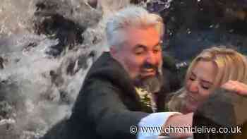 Moment bride and groom fall into river during photoshoot on their wedding day