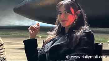 Kaya Scodelario poses in thigh-high boots as she strikes a pose with co-star Maya Jama on the set of The Gentlemen