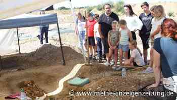 Kinder stehen staunend vor echtem Bajuwaren-Skelett im Neubaugebiet