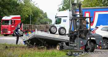 Aanhanger vliegt over de kop in Dongen, vrachtwagenchauffeur schiet te hulp