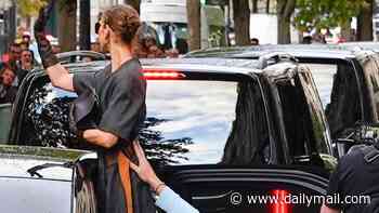 Celine Dion gets a helping hand from a member of her team as she greets fans in fabulous high heels