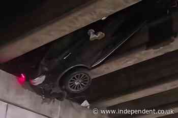 How did this happen?! Viral video shows a car stuck under highway overpass 20 feet in the air