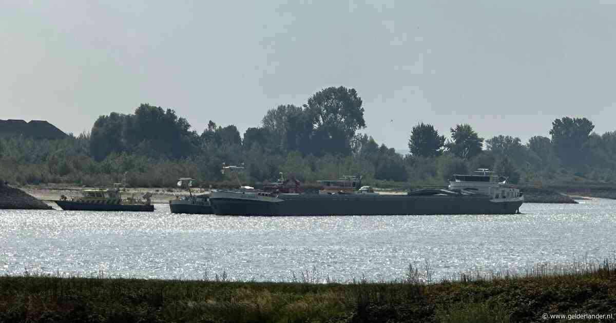 Vrachtschip met kolen lekgeslagen op de Waal en dreigt te zinken, brandweer en Rijkswaterstaat helpen