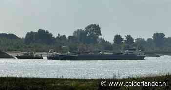 Vrachtschip met kolen lekgeslagen op de Waal en dreigt te zinken, brandweer en Rijkswaterstaat helpen
