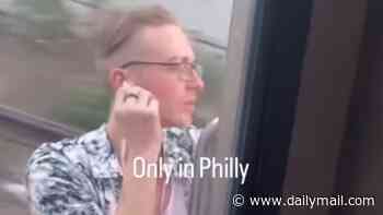 Idiot man in Hawaiian shirt seen enjoying the breeze as he rides OUTSIDE Philadelphia train traveling at high speed