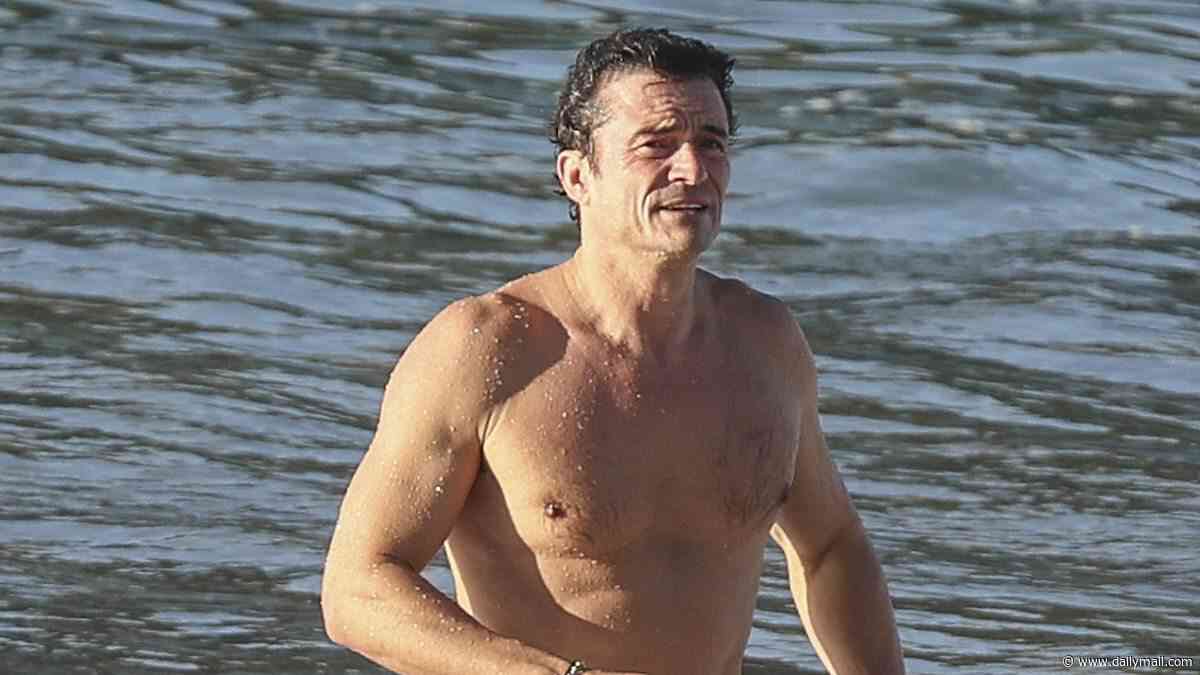 Orlando Bloom, 49, shows off his ripped physique as he emerges from the sea after a swim in Spain