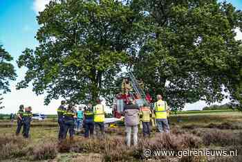 Parachutist vast in boom, brandweer zet springkussen in
