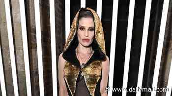 Kelly Osbourne turns heads in a hooded gold jumpsuit as she attends John Richmond's London Fashion Week show after hitting the catwalk