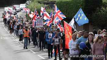 Protesters march in town after former military base is turned into asylum camp housing 540 male migrants