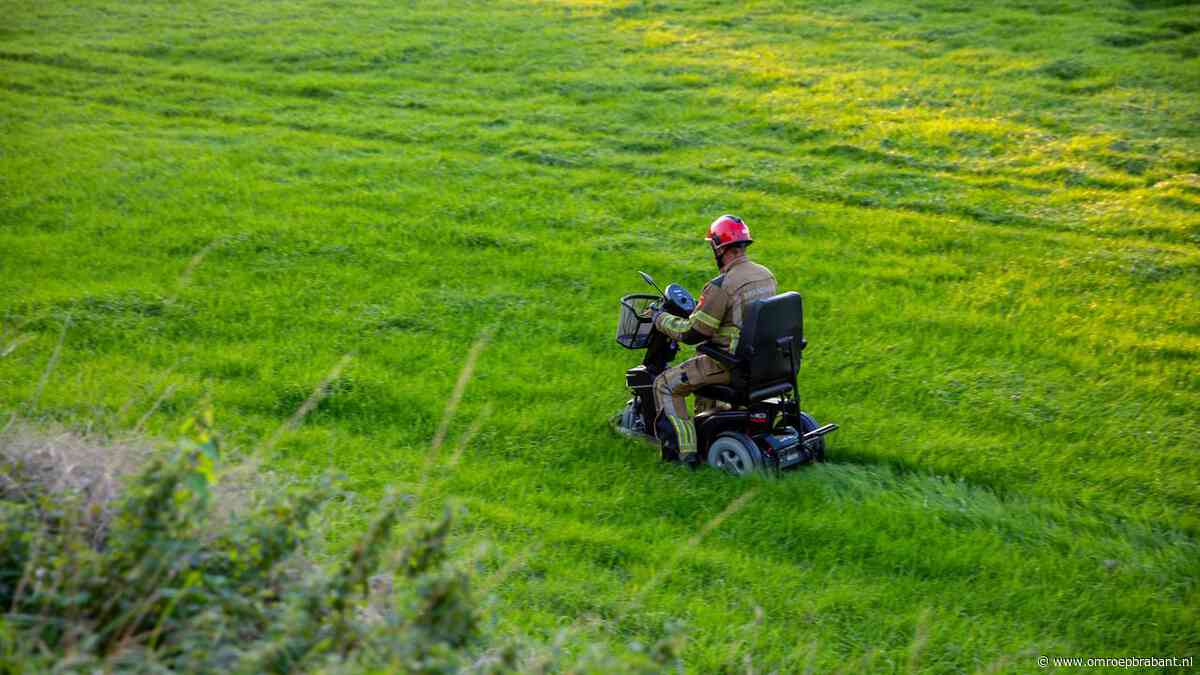 Vrouw rijdt met scootmobiel van de dijk, brandweer schiet te hulp